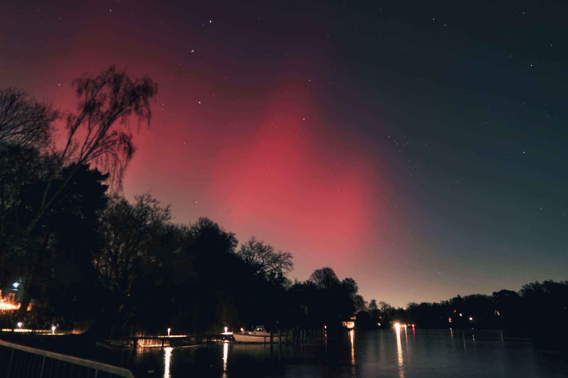 Red aurora bands glowing against the dark Wannsee  night sky.